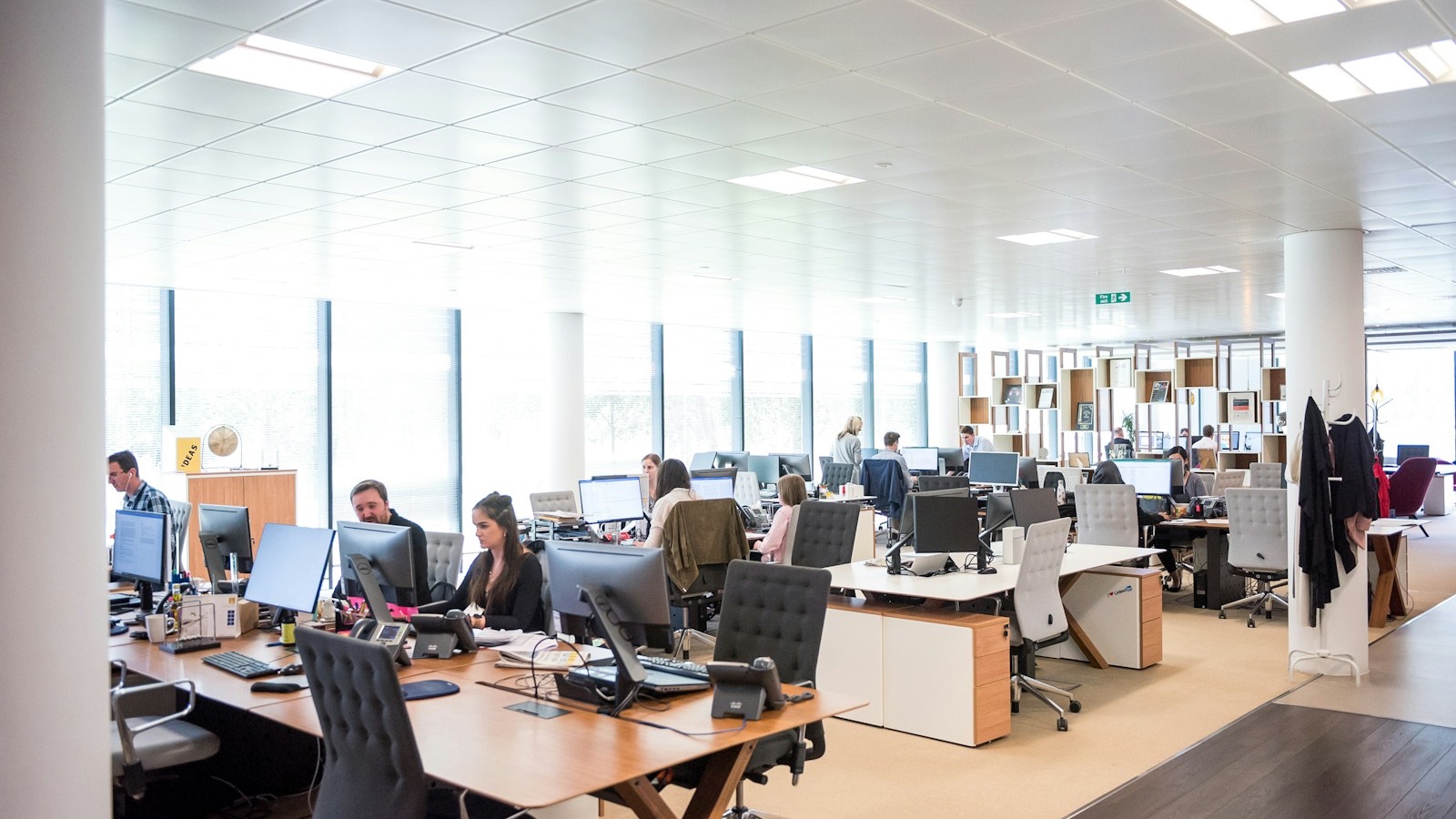 A large open plan office with people working at their computers